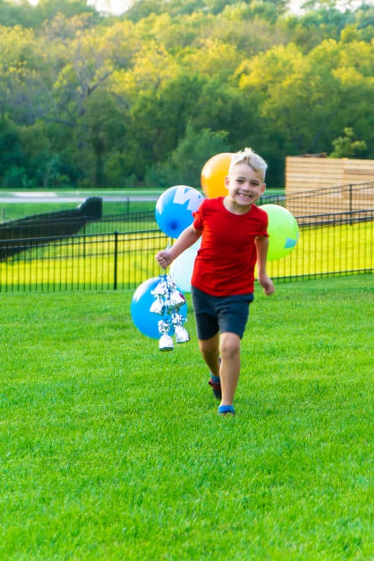 Kid holding spelling games balloons