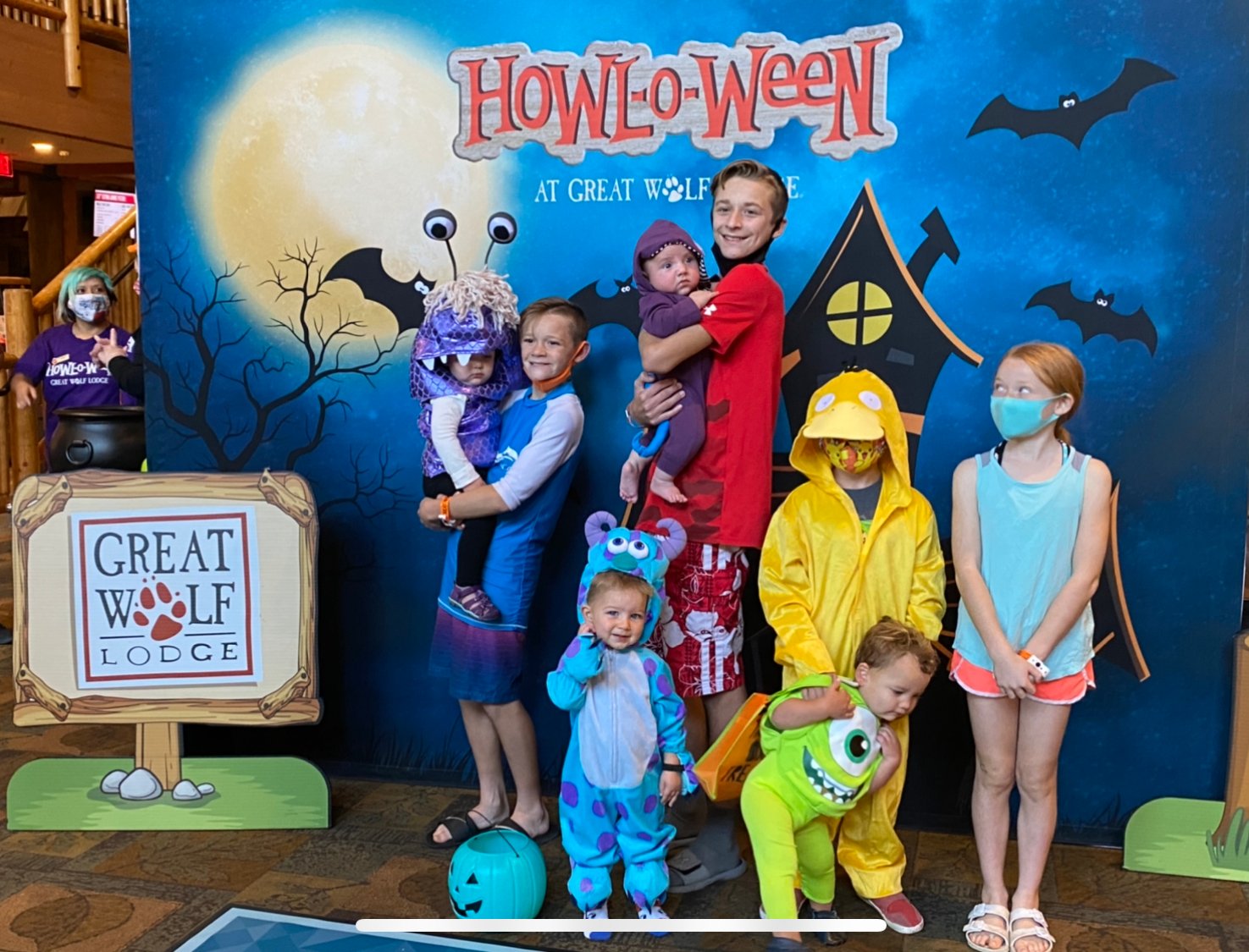 family in costume in front of Great Wolf sign