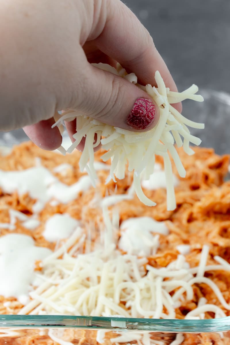 Topping buffalo chicken dip with cheese