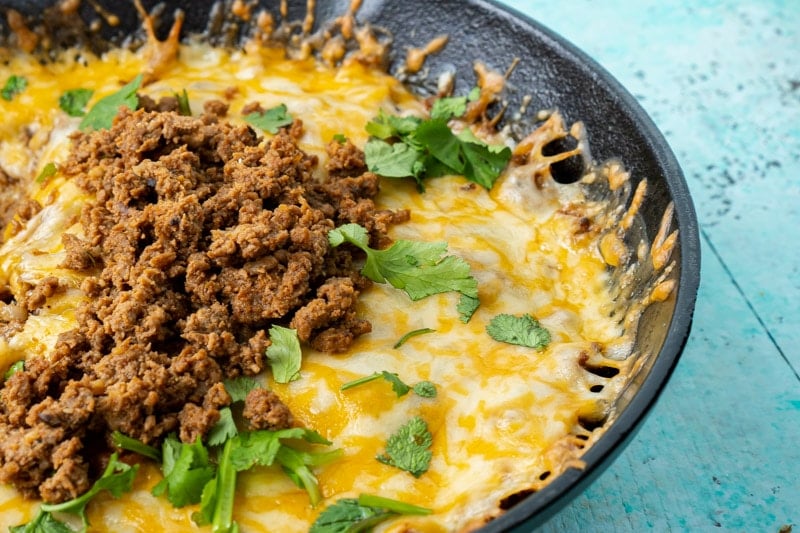 A cast iron skillet with queso fundido