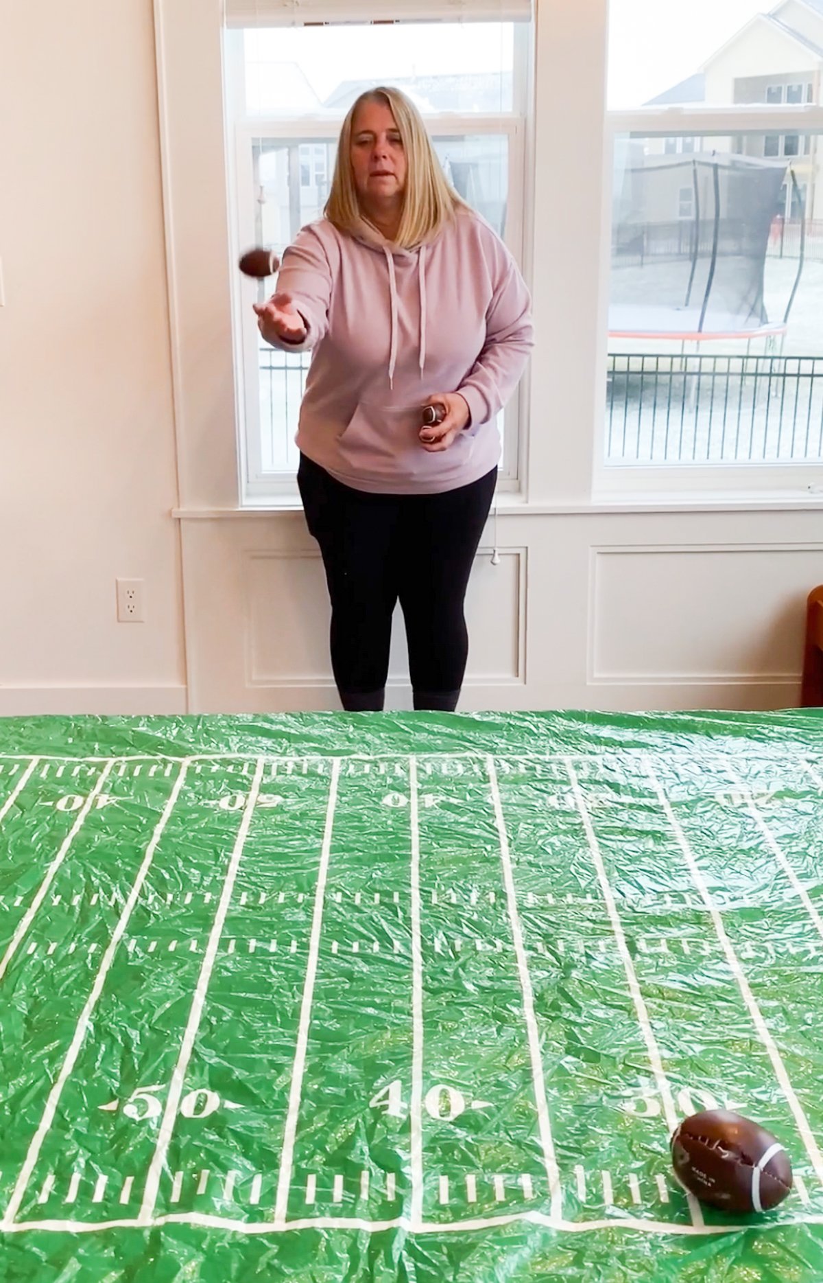 woman tossing footballs onto a table