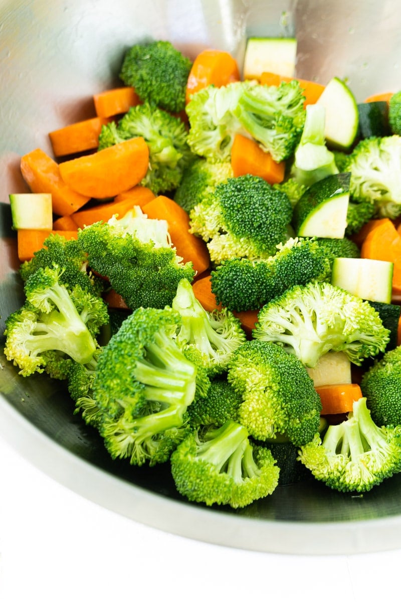 Veggies being tossed for sheet pan teriyaki chicken