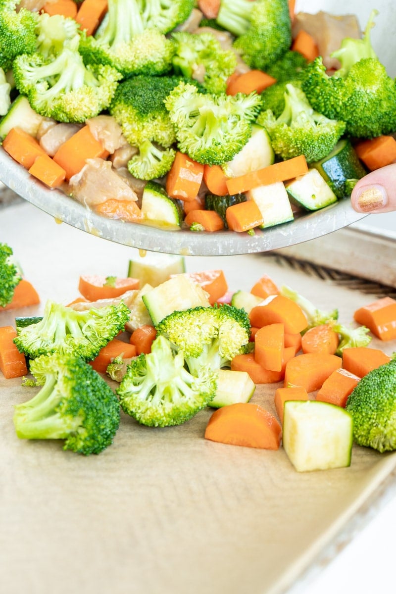 Adding food to sheet pan teriyaki chicken