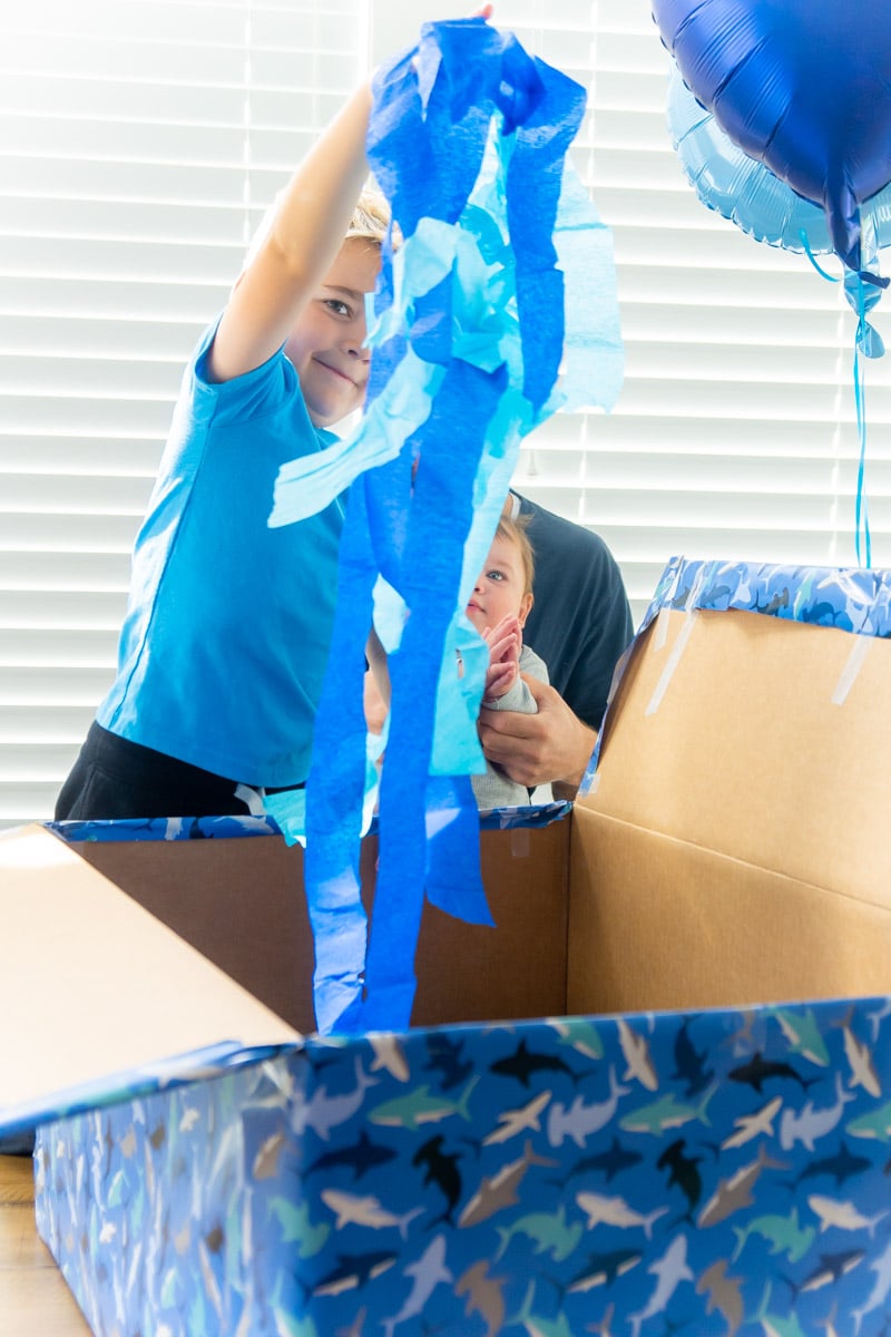 Adding streamers to blue gift box