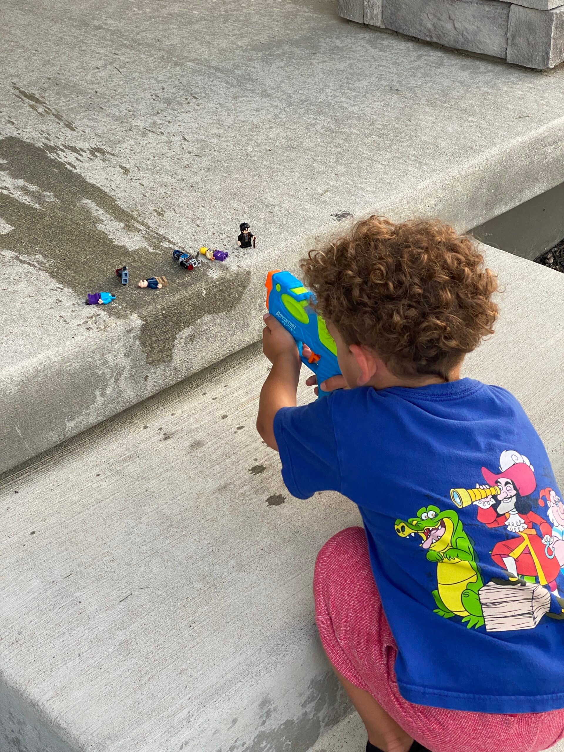 kid shooting LEGO guys with a squirt gun