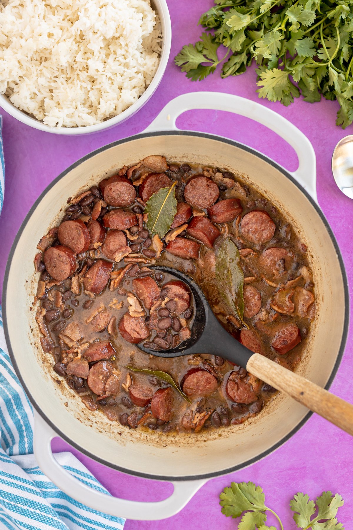a big pot full of Brazilian feijoada with a spoon in it