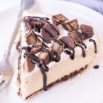 Slice of peanut butter pie on two plates with a blue napkin