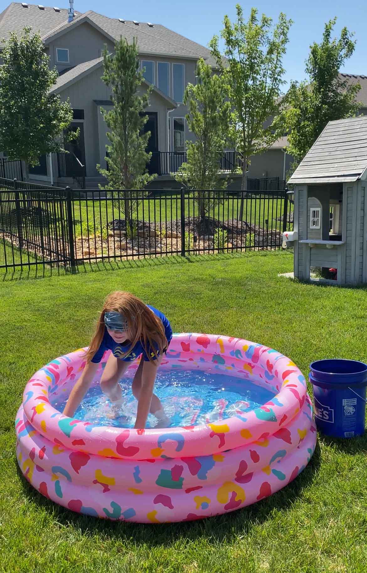 blindfolded girl standing in a kiddie pool