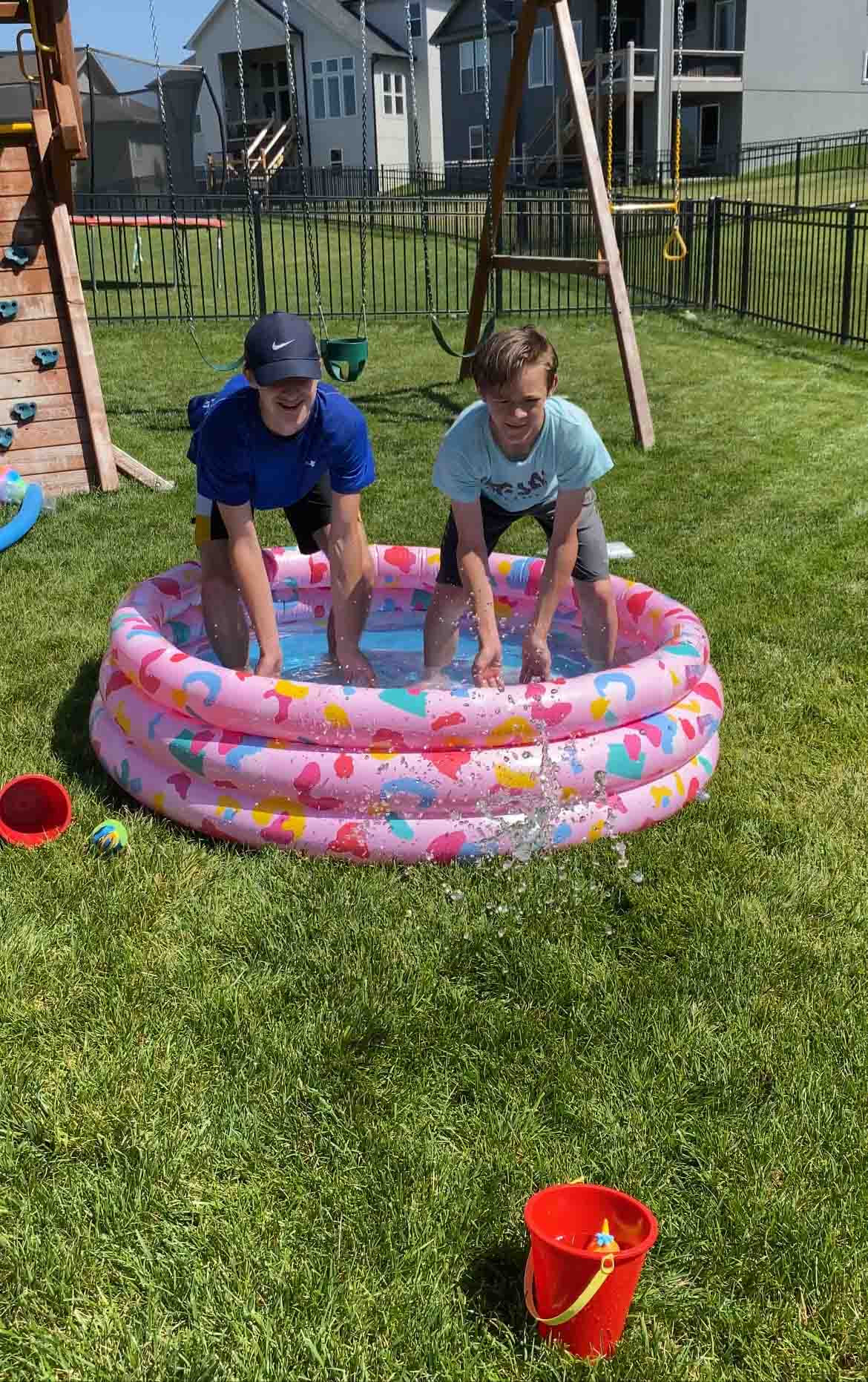 kids splashing water from a pool to a cup