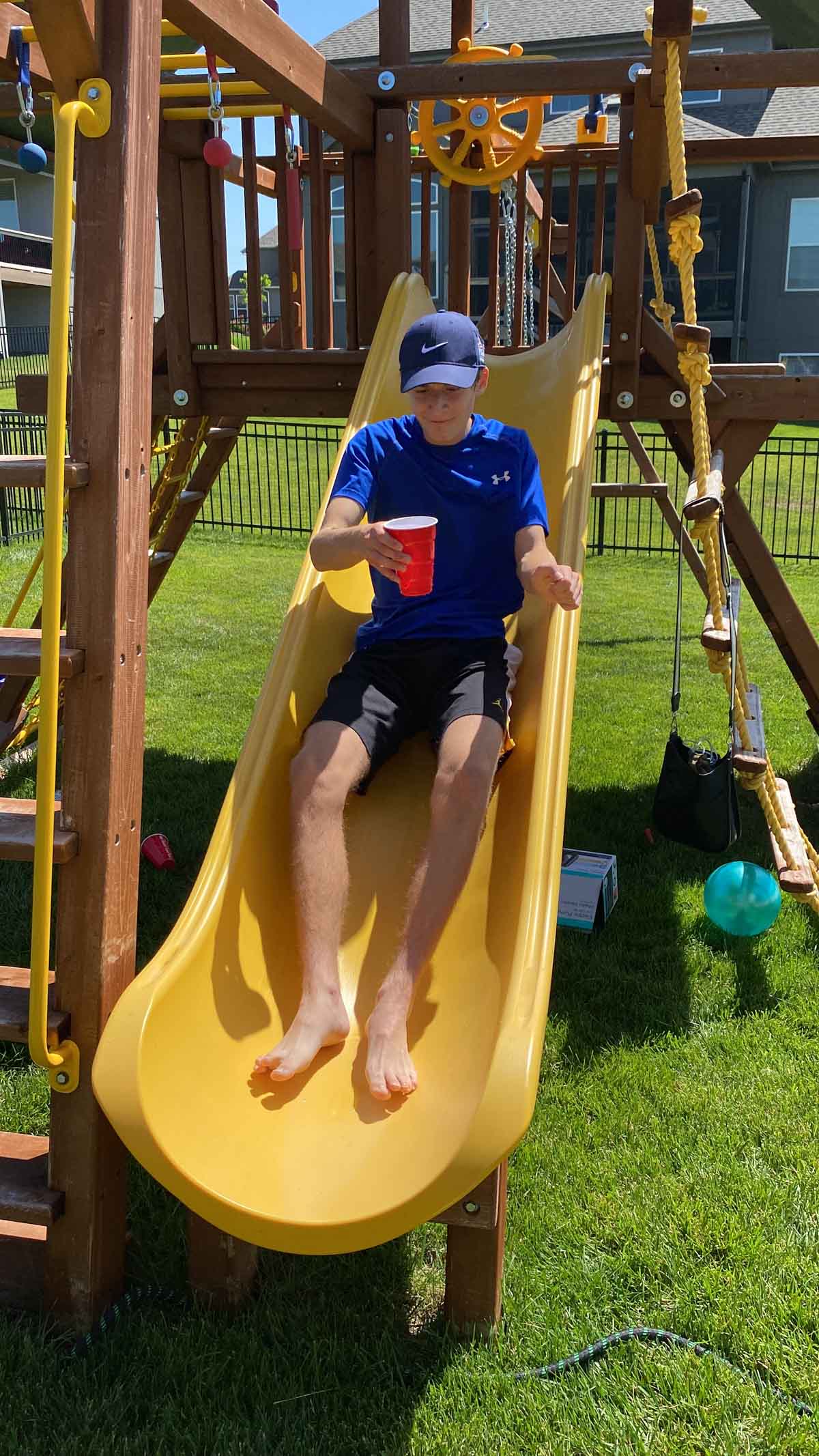 kid sliding with a cup full of water