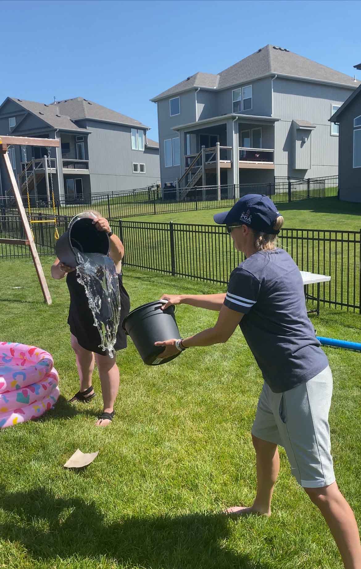 two women tossing water between buckets