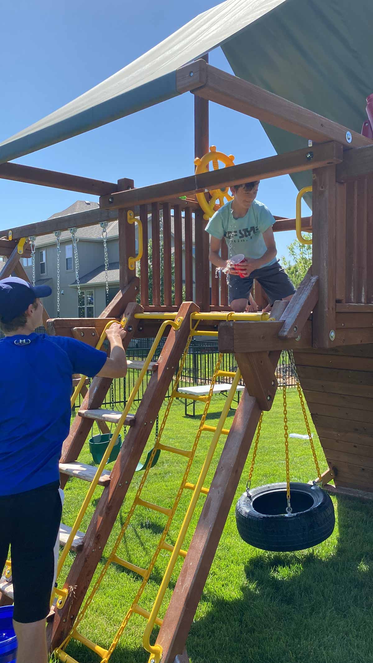 two boys passing water on a playground