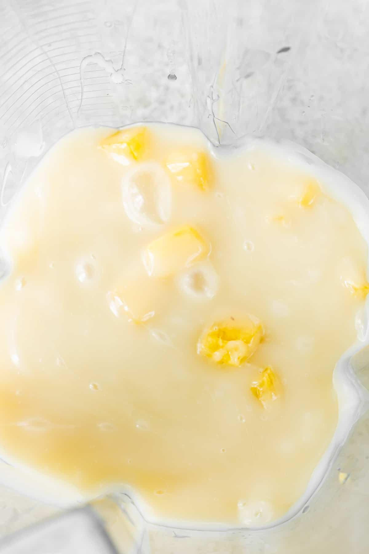 Pineapple and sweetened condensed milk in a blender for a pina colada dipping sauce