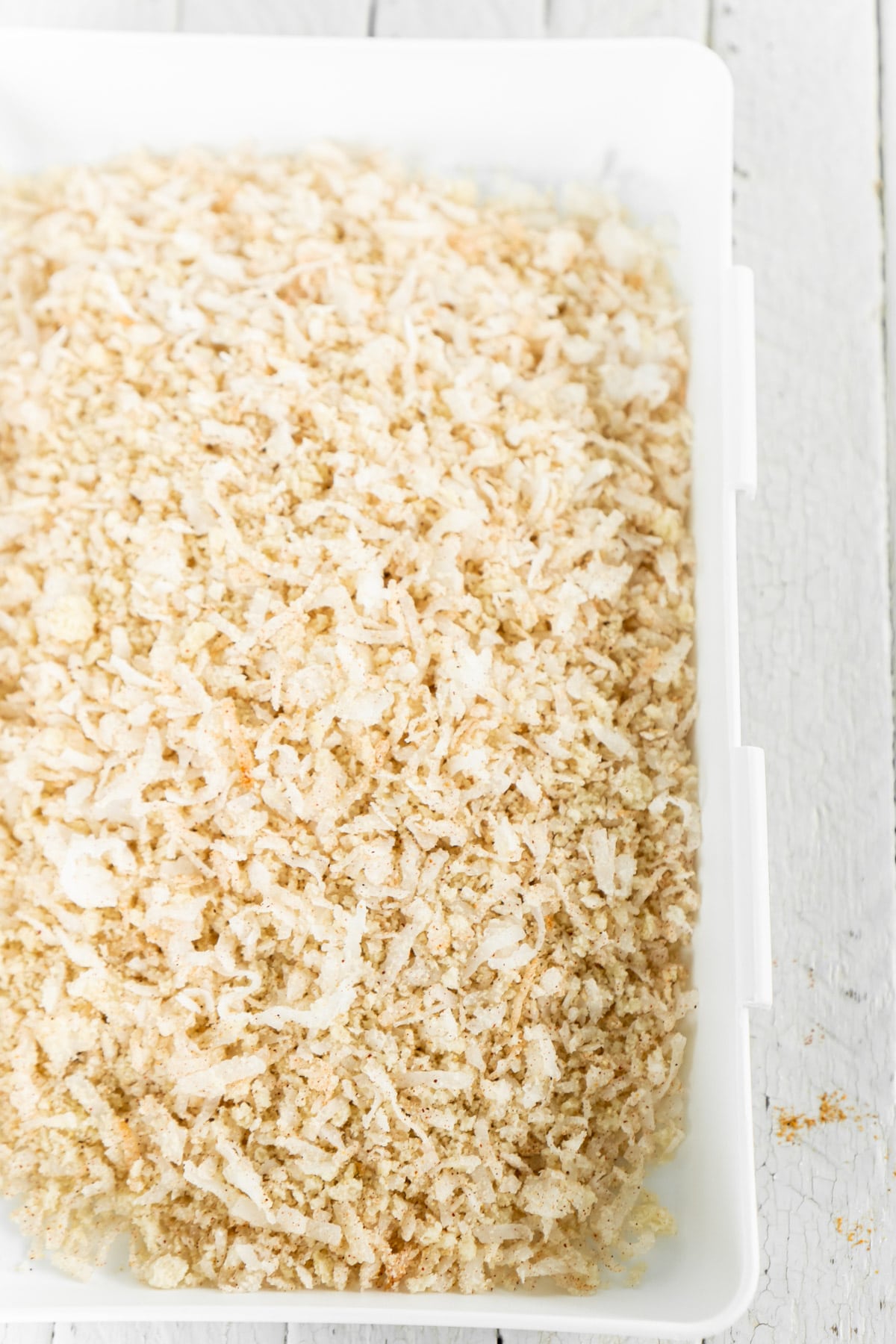 Coconut chicken breading in a white rectangle dish