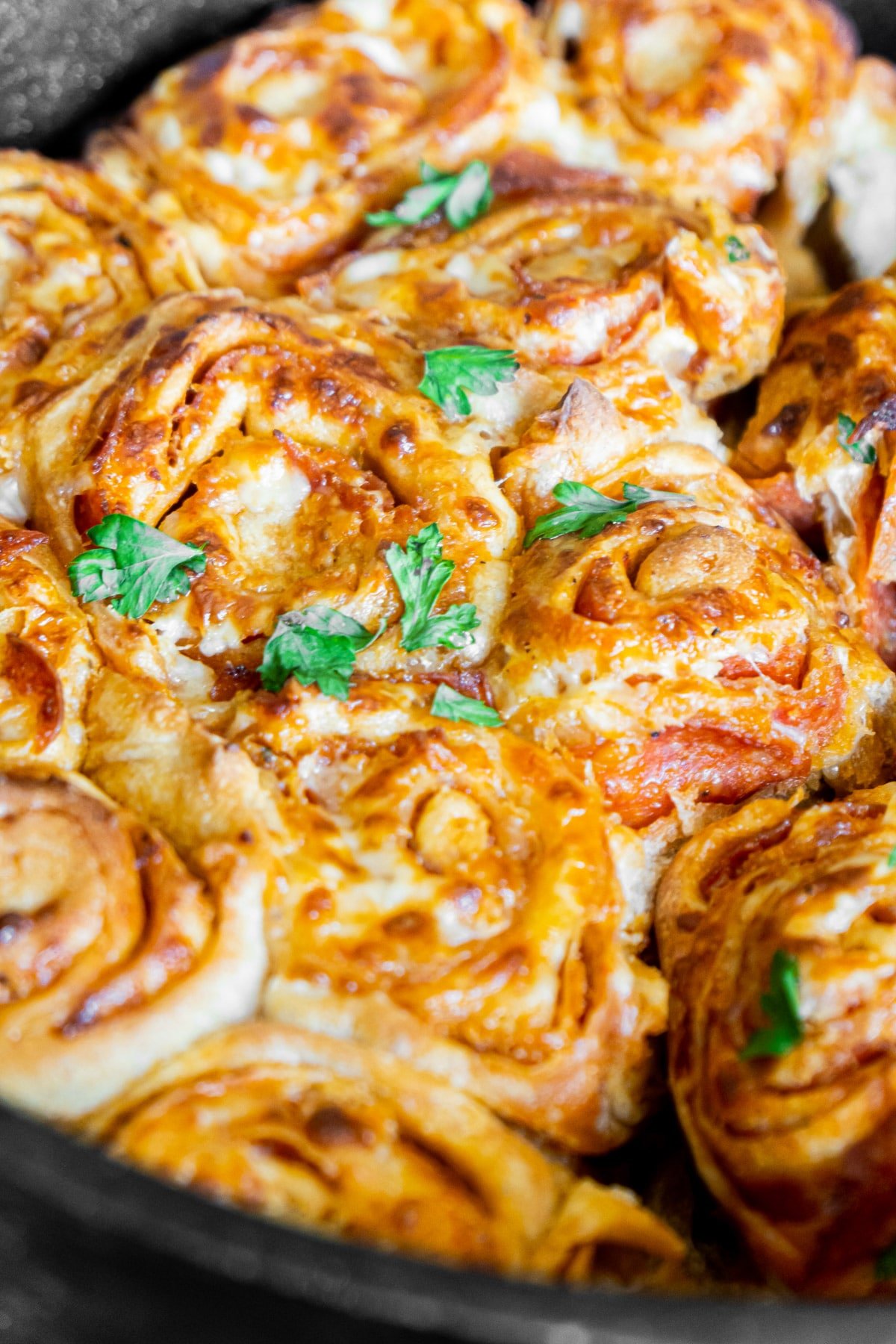 Baked pepperoni rolls in a dutch oven with parsley on top