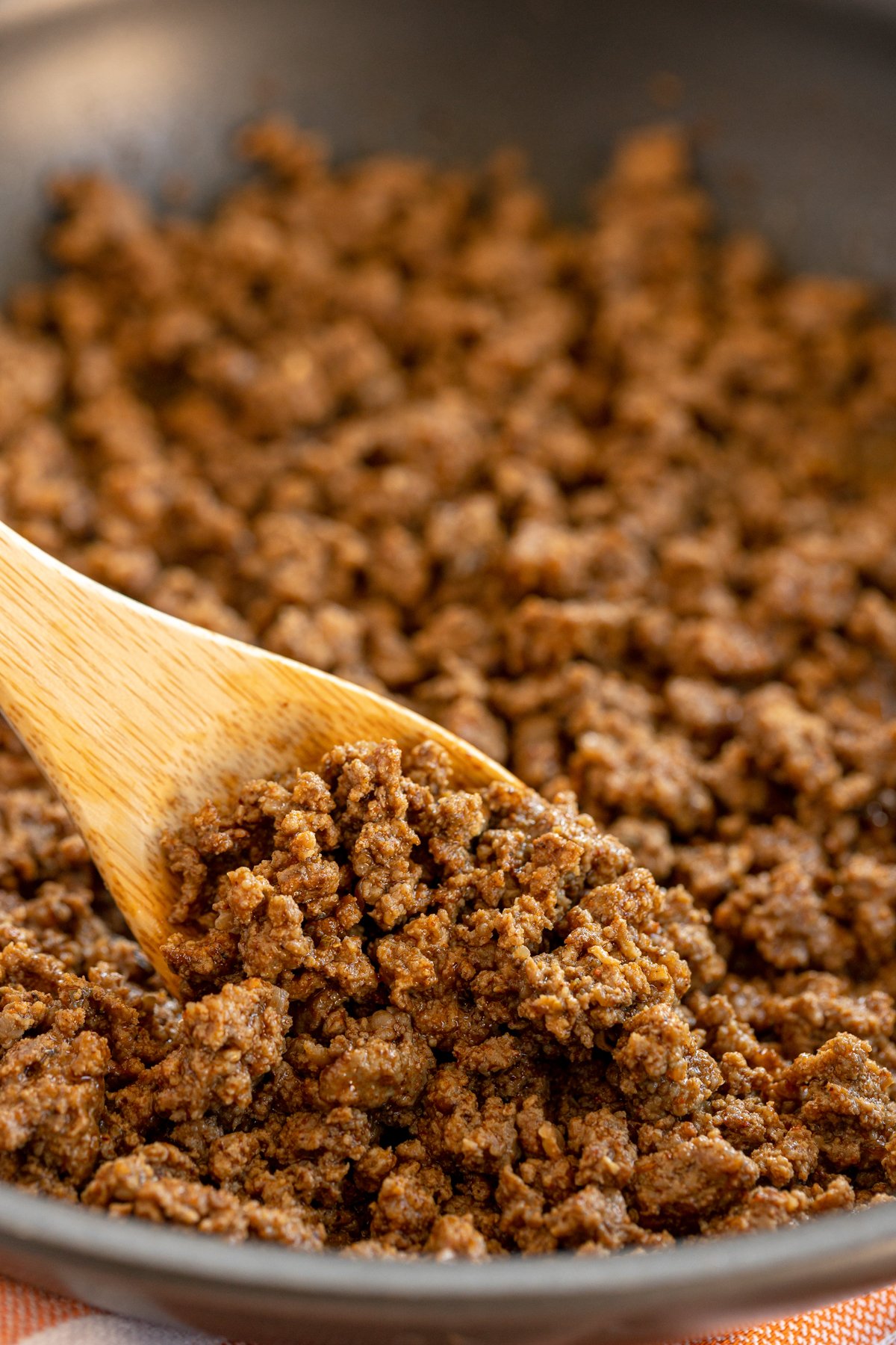 pan with a wooden spoon dishing up some homemade taco meat