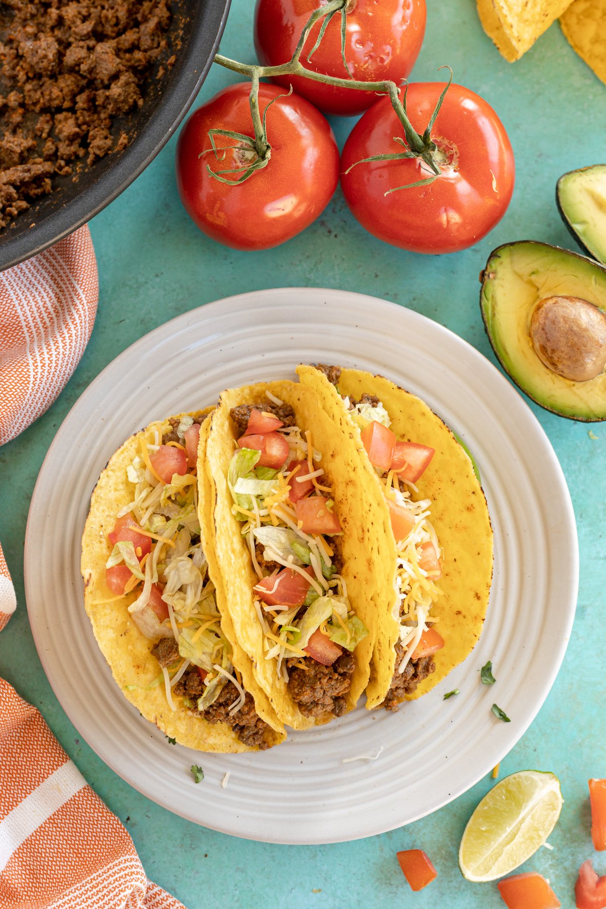 three homemade ground beef tacos on a white plate