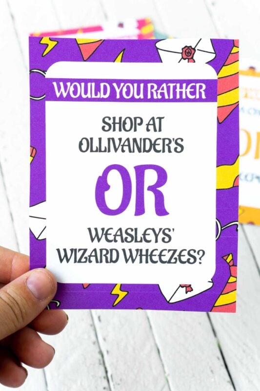 A woman's hand holding a Harry Potter would you rather card