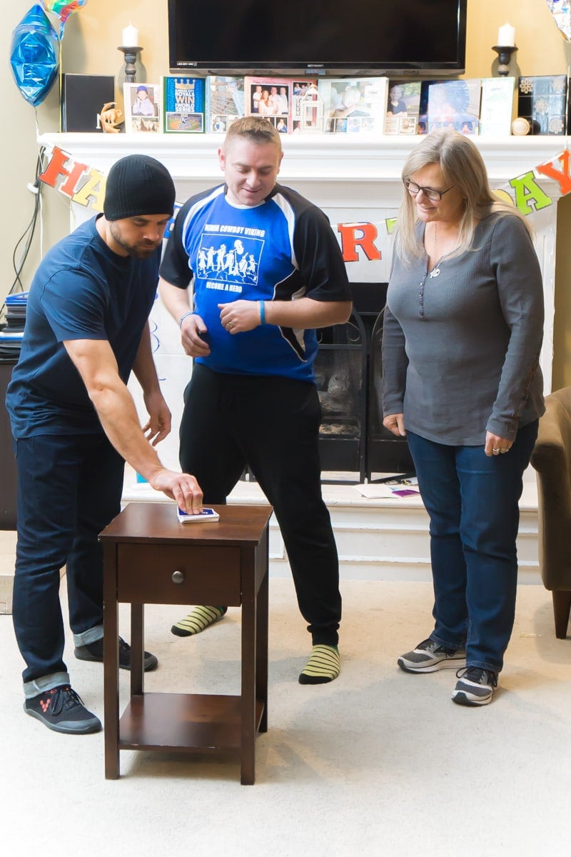 three adults looking at a card while playing games