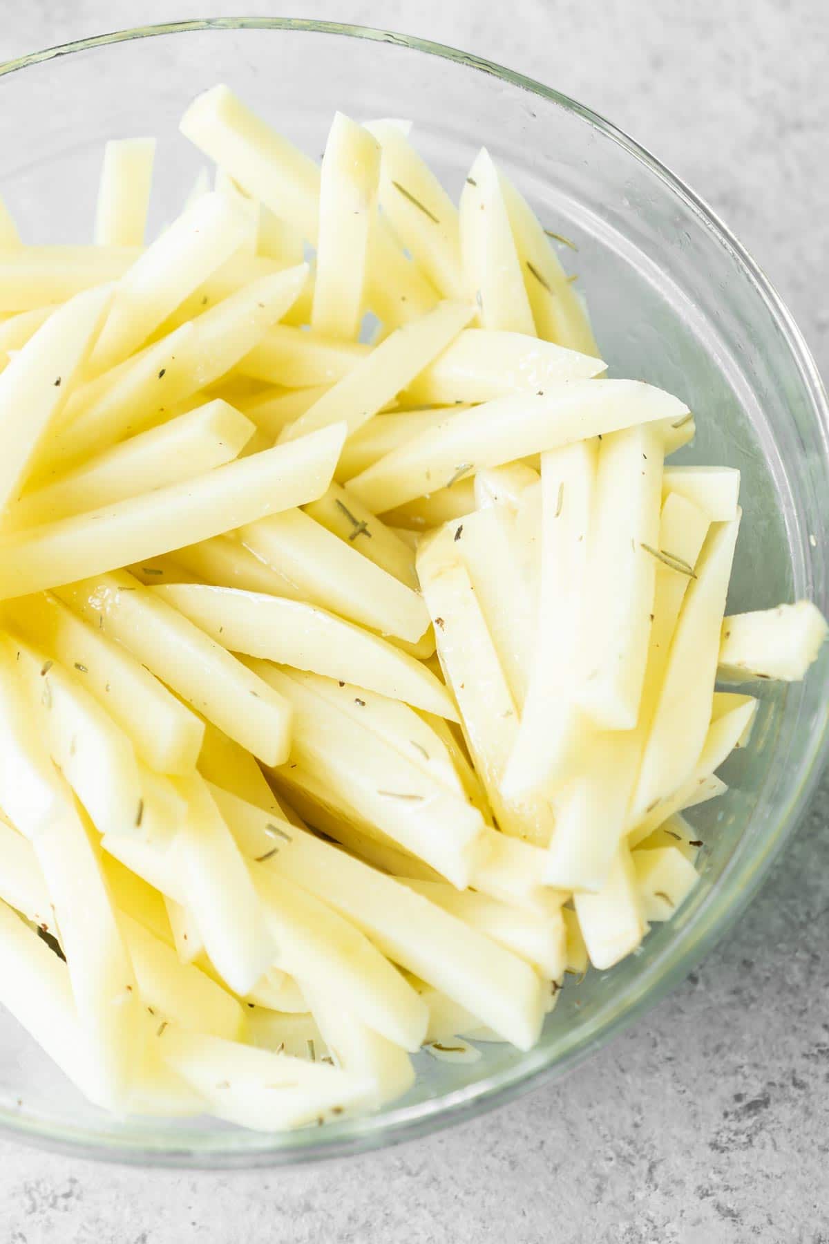 A glass bowl full of cut potatoes