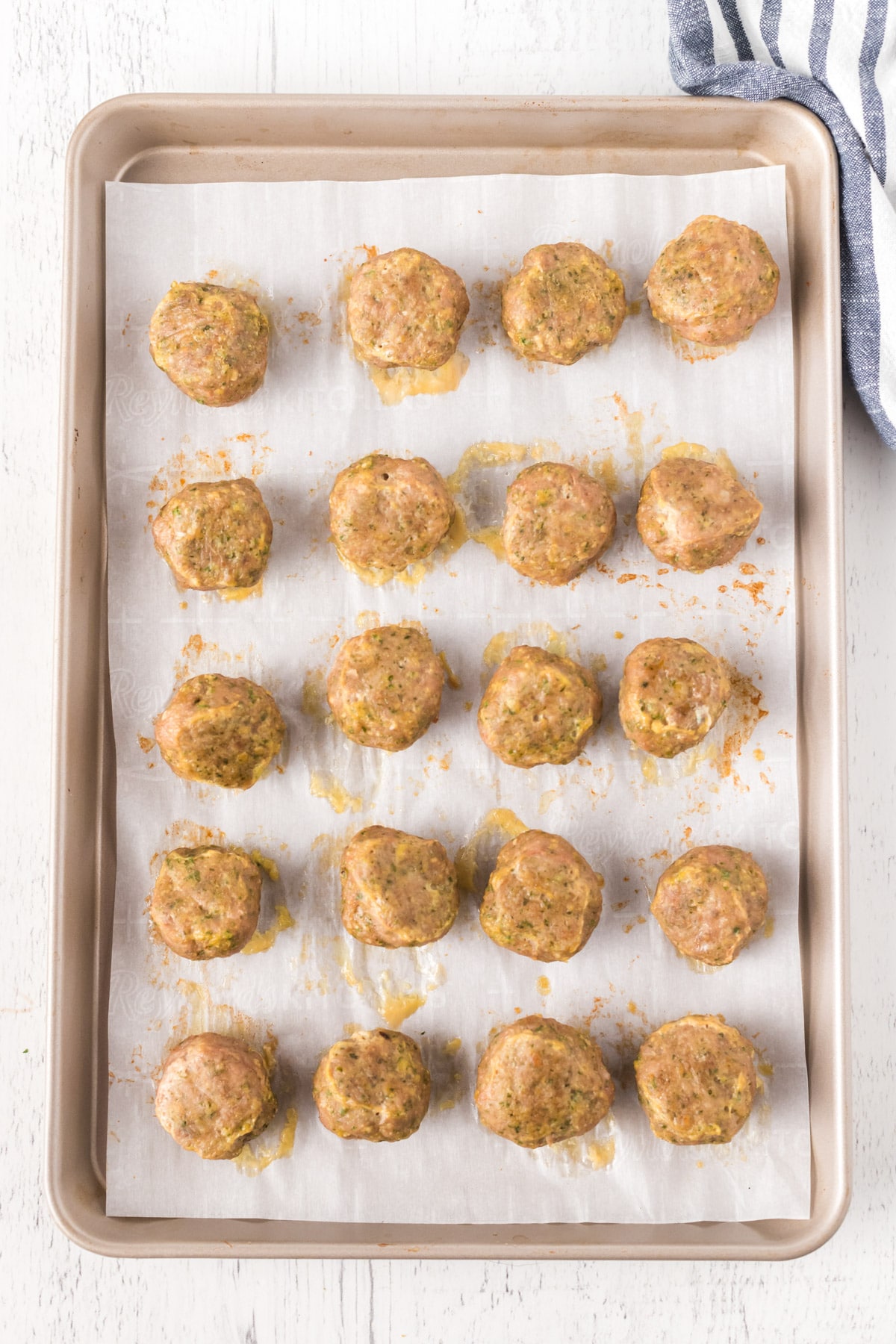 Baked turkey meatballs on a baking sheet with parchment paper