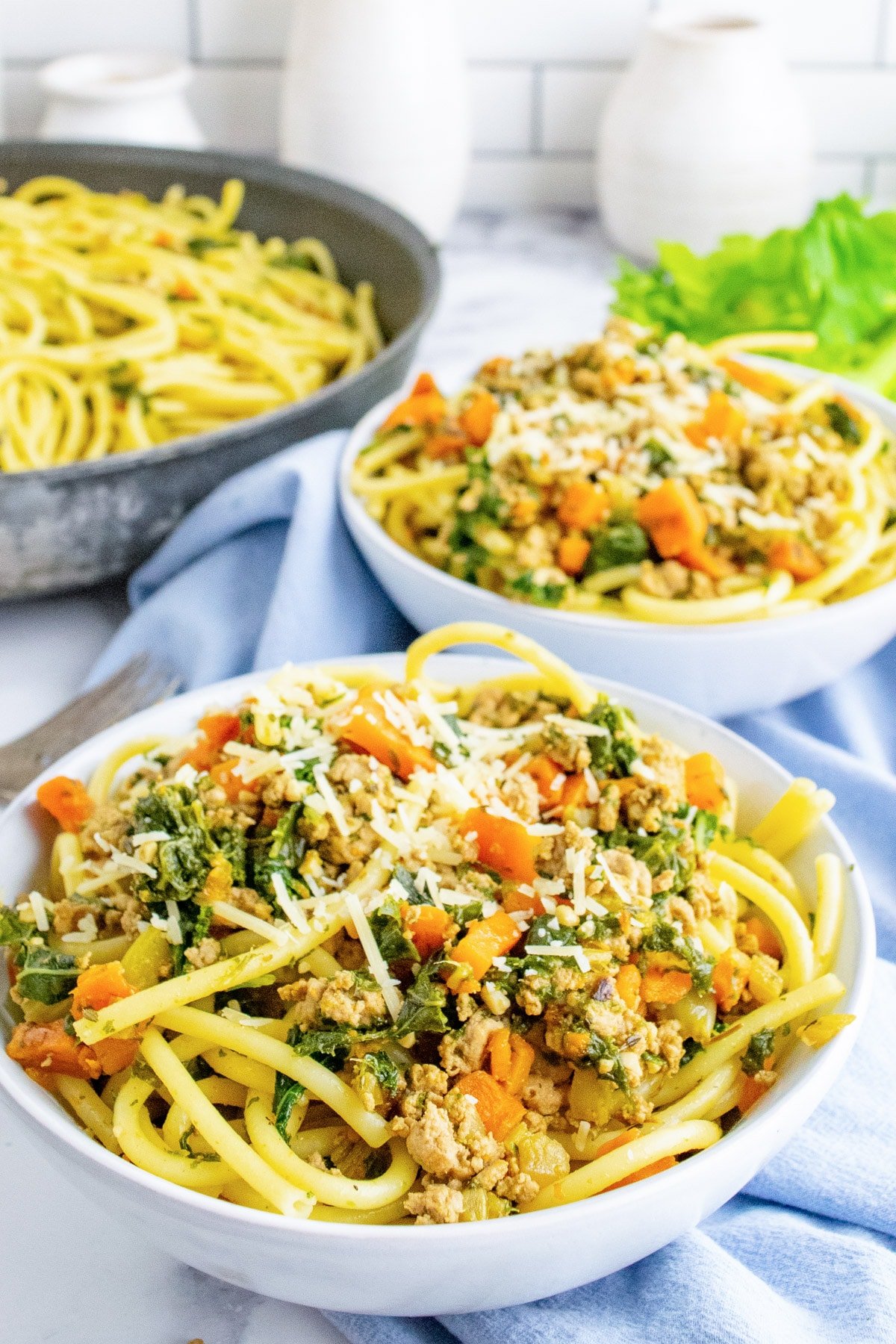 A bowl of ground turkey pasta with another bowl in the background