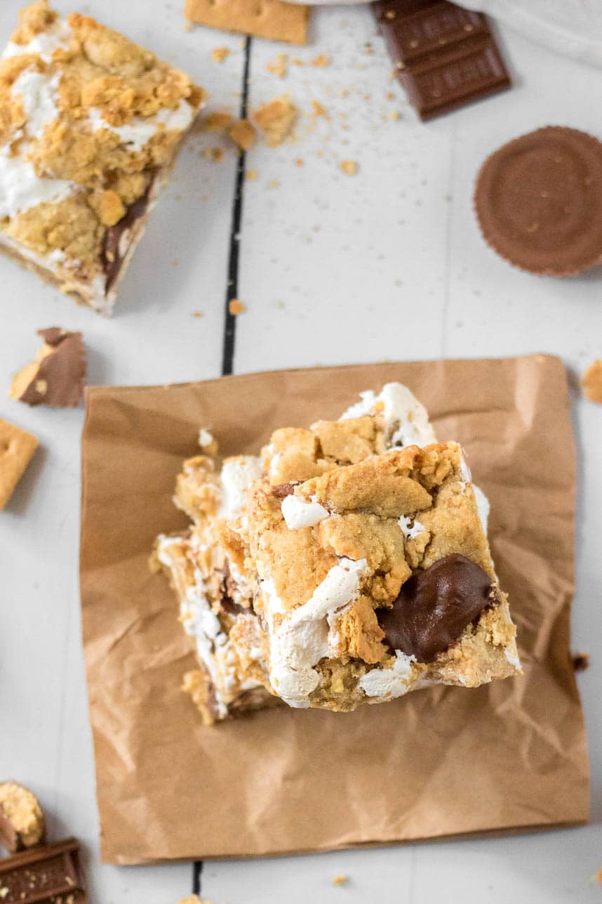 Peanut butter smore bar on a brown napkin with a white wood background