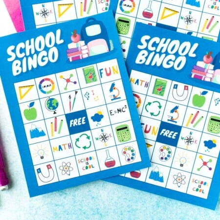 Four blue bingo cards with two pencils