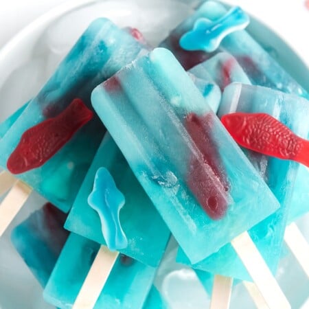A horizontal photo of a pile of blue lemonade popsicles on top of each other