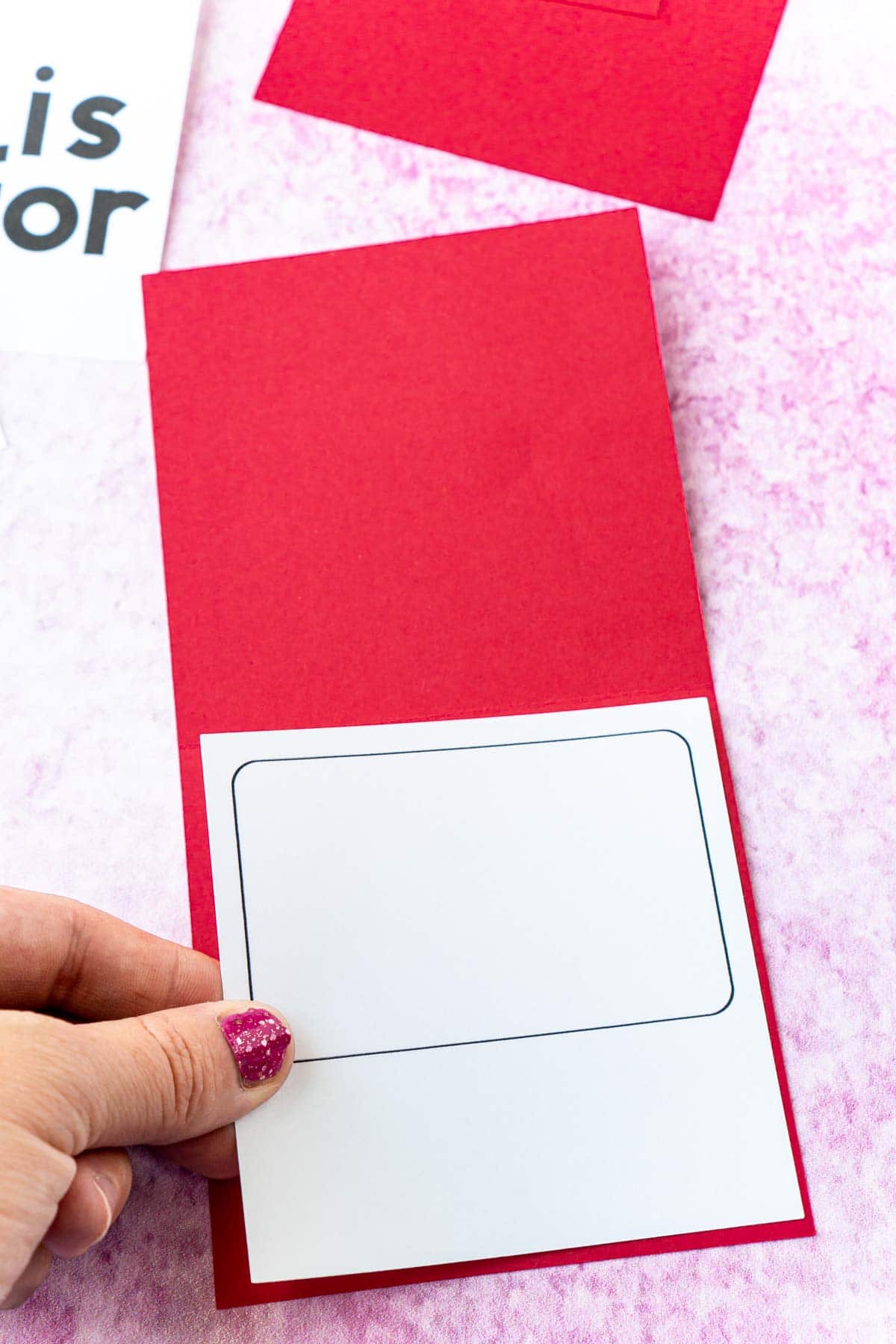 Woman's hand adding a gift card holder to a red card