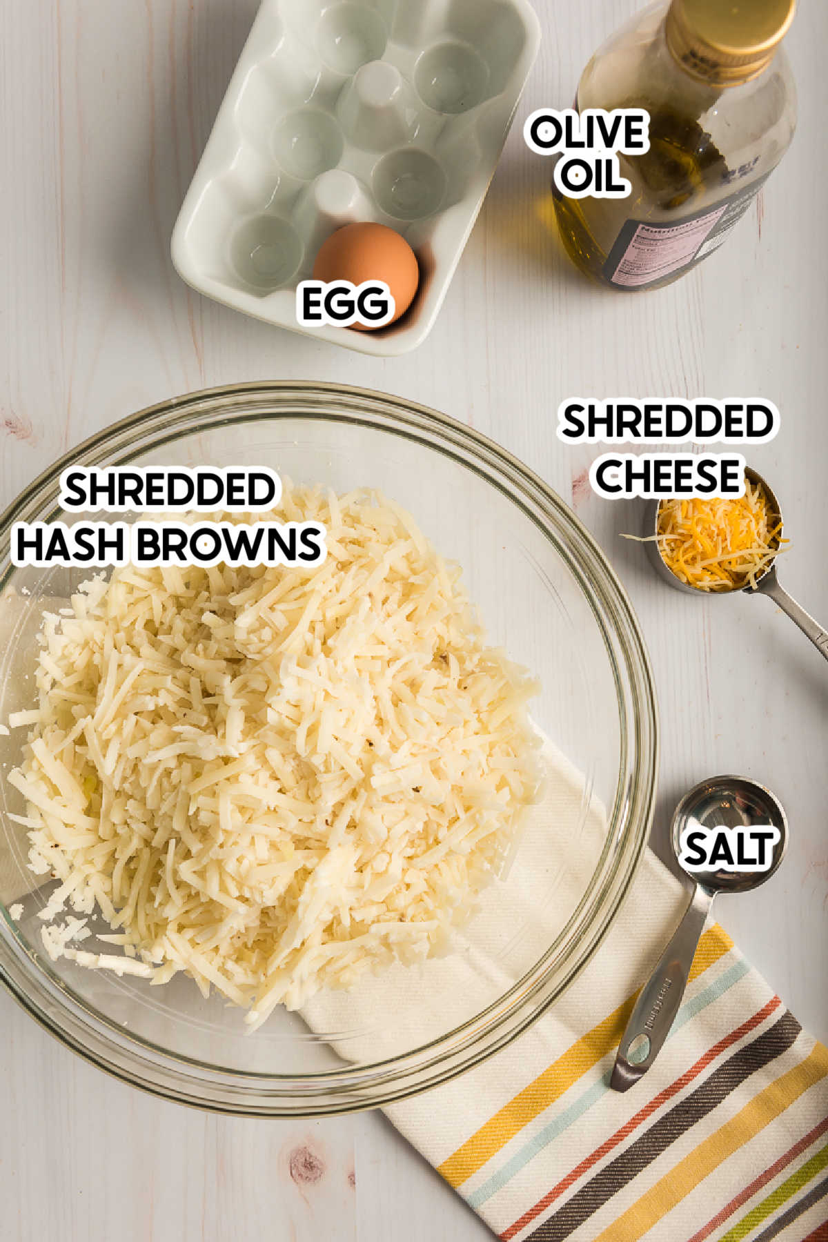 Glass bowl with hash browns and other ingredients with text labels on top