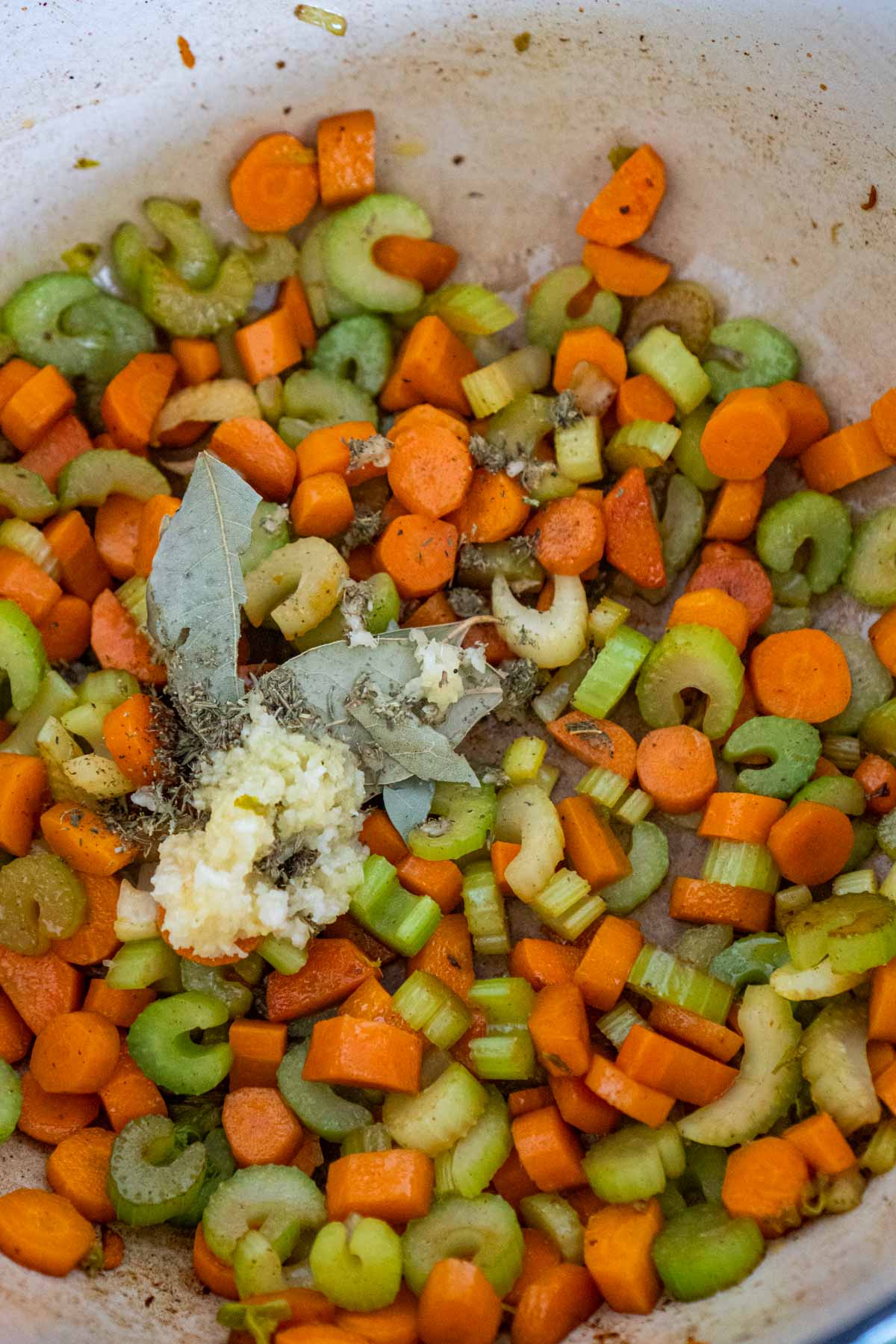 Spices added into a pot of celery and carrots