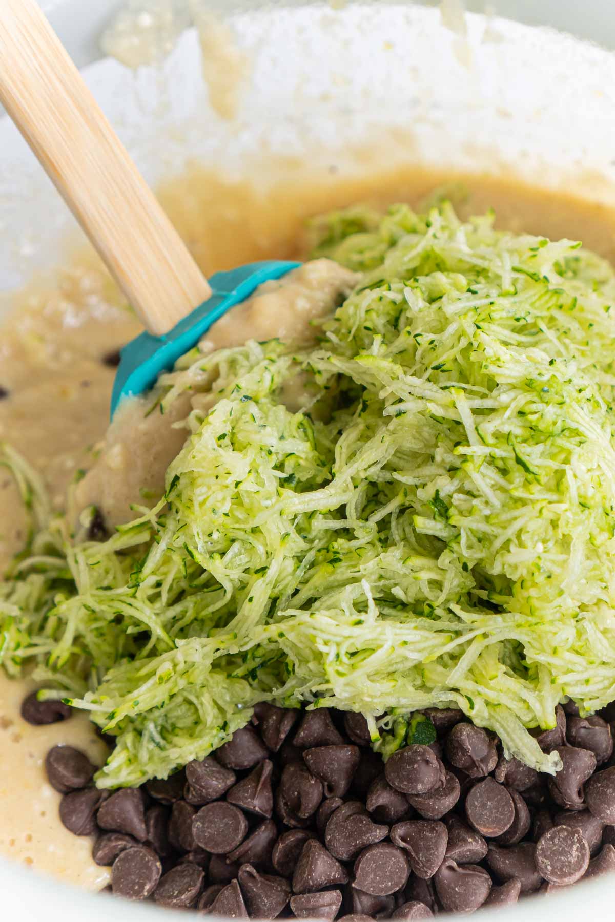 Bowl with shredded zucchini, chocolate chips, and zucchini bread batter