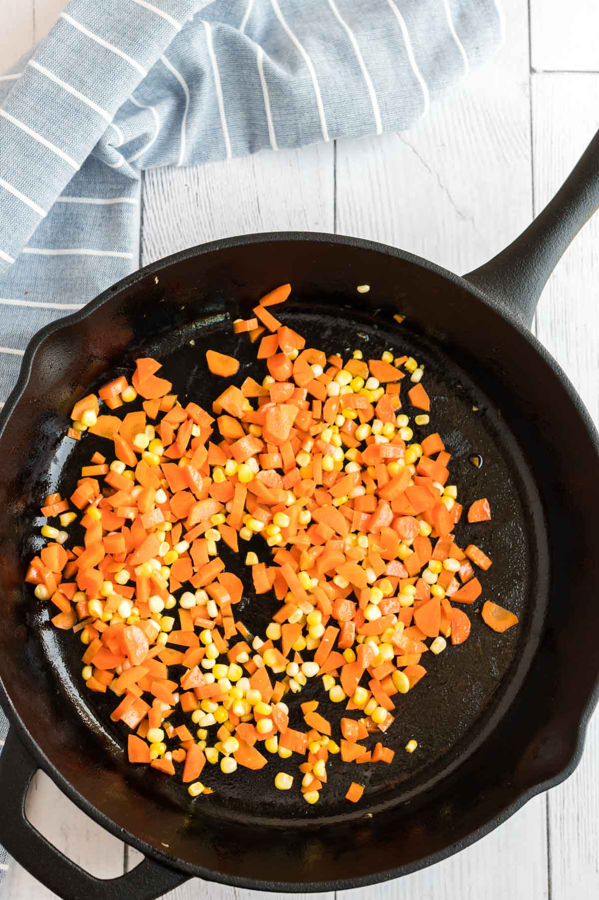 Chopped carrots and corn in a cast iron pan