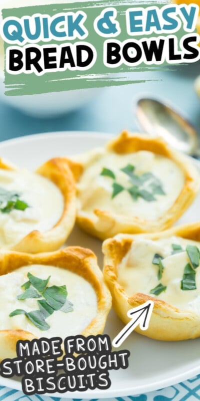 Four bread bowls with chowder on a white plate with text for Pinterest