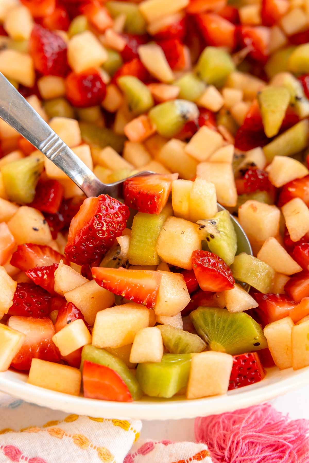 spoon in a white bowl of fruit salsa