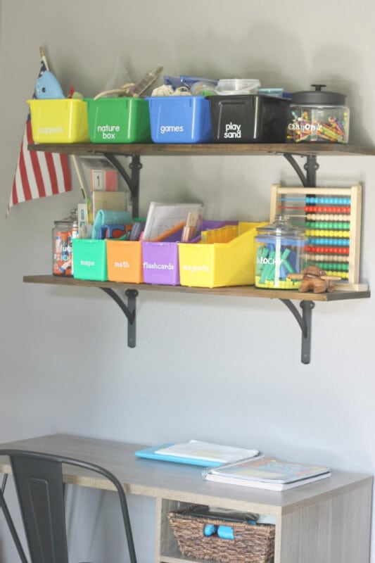 A shelf with colorful storage buckets, labels, and personalize school supplies