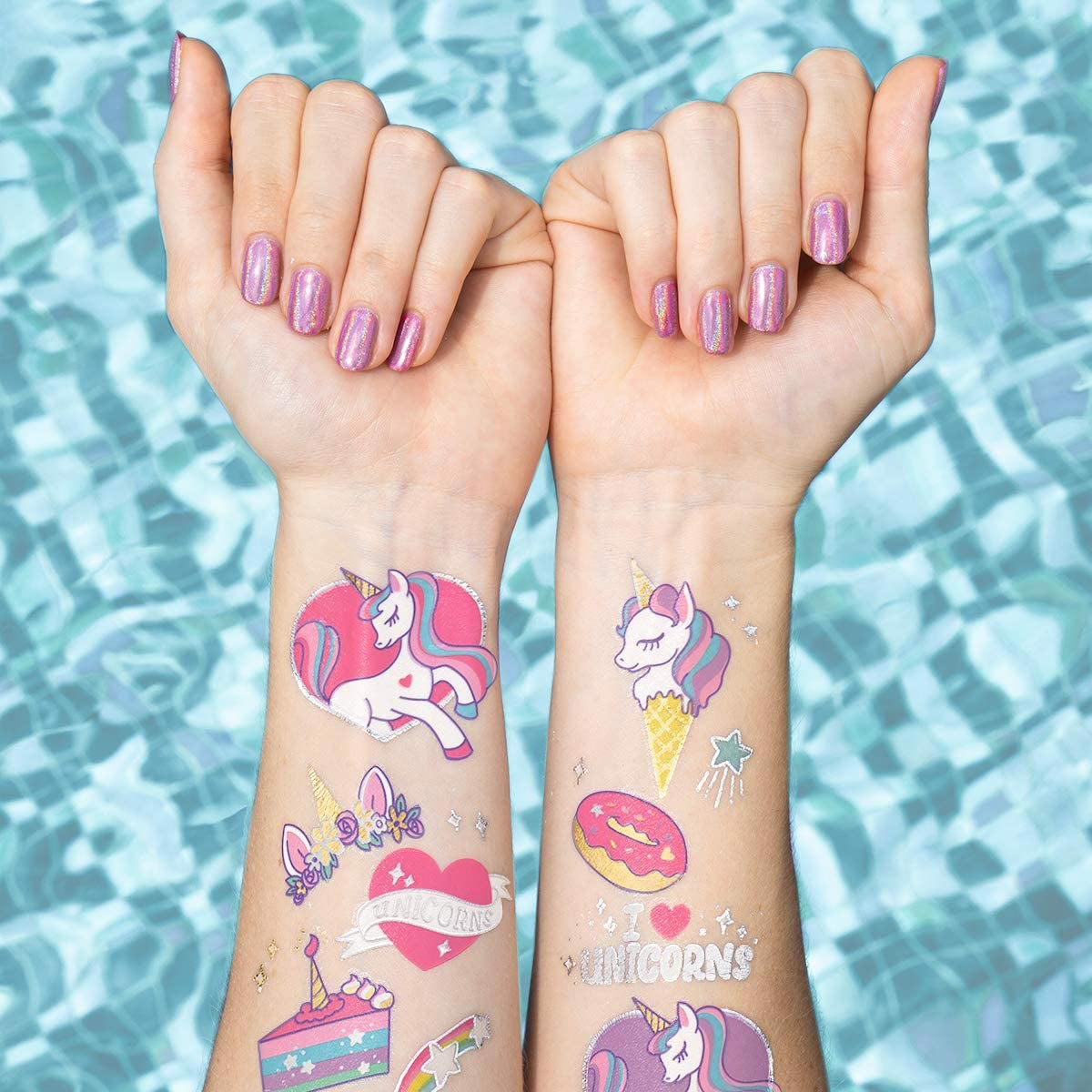 Girls arms with unicorn tattoos over a swimming pool