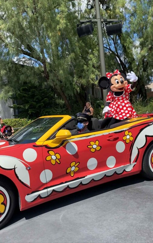 Minnie mouse in a red car waving