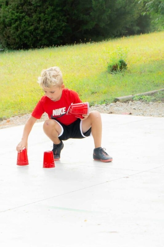 Kid placing plastic cups on a basketball court