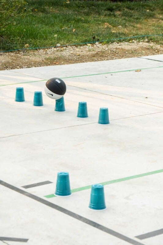 Basketball hitting a plastic cup on a basketball court