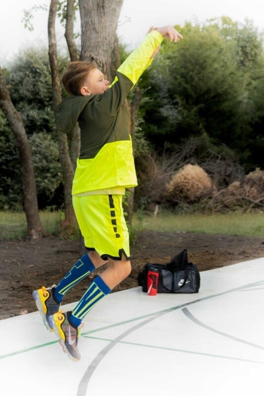 Kid in yellow clothes jump shooting a basketball