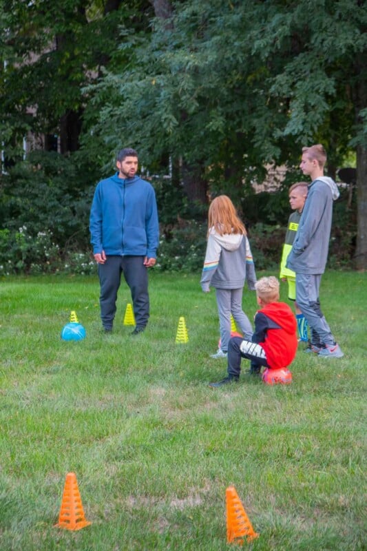 Adult explaining how to play soccer to kid