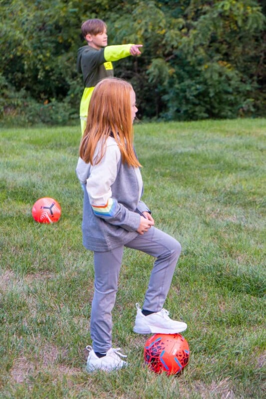 Girl with her foot on a pink soccer ball