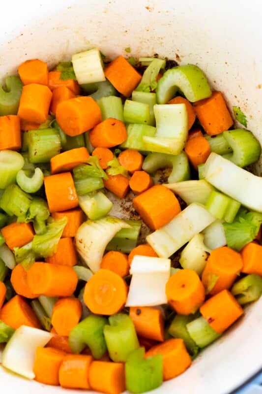 A dutch oven with celery and carrots in it