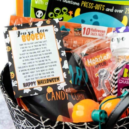 Spiderweb basket filled with Halloween books, games, and a you've been booed sign