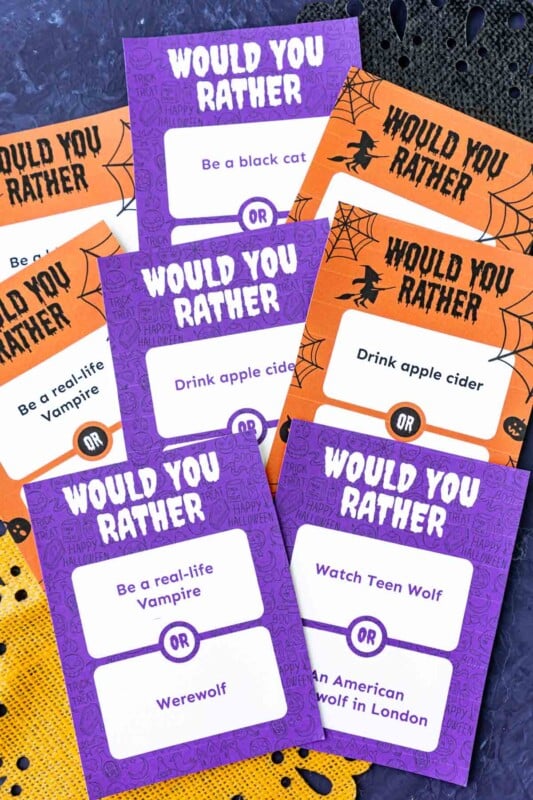 Purple and orange papers with Halloween themed would you rather questions on them