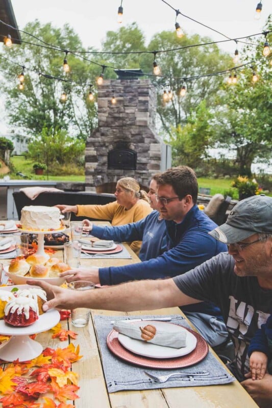 People grabbing food at a fall table