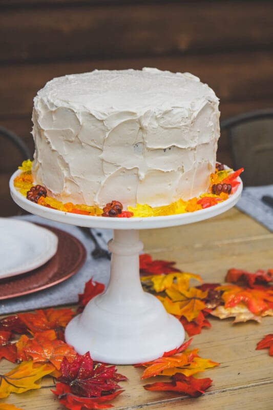 White cake with fall colored jewels on a white cake stand