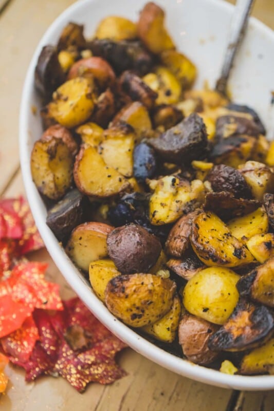 White bowl full of brick oven cooked potatoes